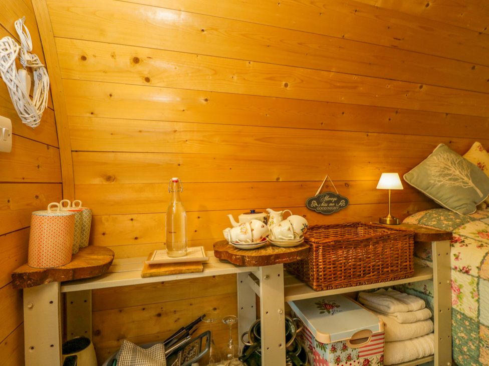 A bedroom with shelves containing mugs and teacups at Daisy Glamping Pod in Woolton Hill