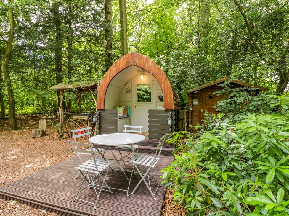 An outdoor area with a glamping pod and seating at Daisy Glamping Pod in Woolton Hill