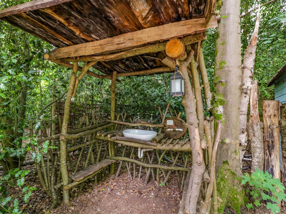 An outdoor bathroom with a wooden sink and structure at Daisy Glamping Pod Woolton Hill