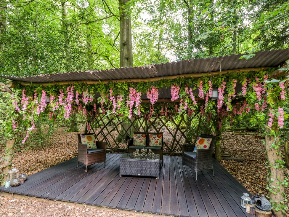 An outdoor seating area with chairs and a table at Daisy Glamping Pod in Woolton Hill
