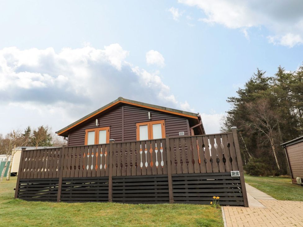 A lodge with a balcony and pathway at Nevaeh Lodge Longframlington