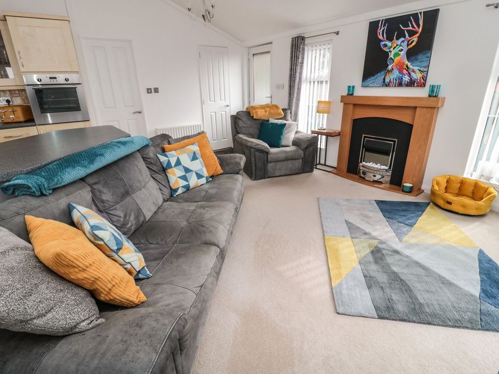 A living room with a sofa and armchair at Nevaeh Lodge in Longframlington