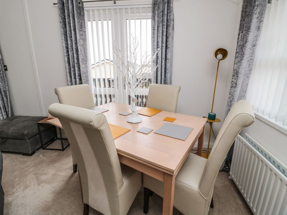 A dining room with a table and chairs at Nevaeh Lodge Longframlington
