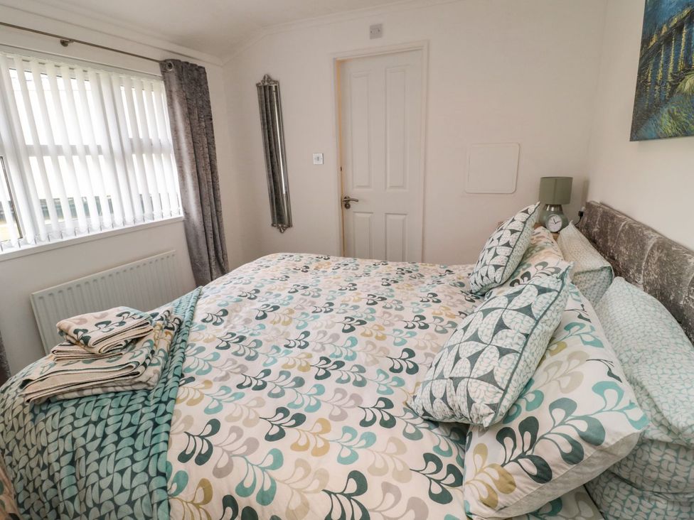 A bedroom with a bed and pillows at Nevaeh Lodge Longframlington