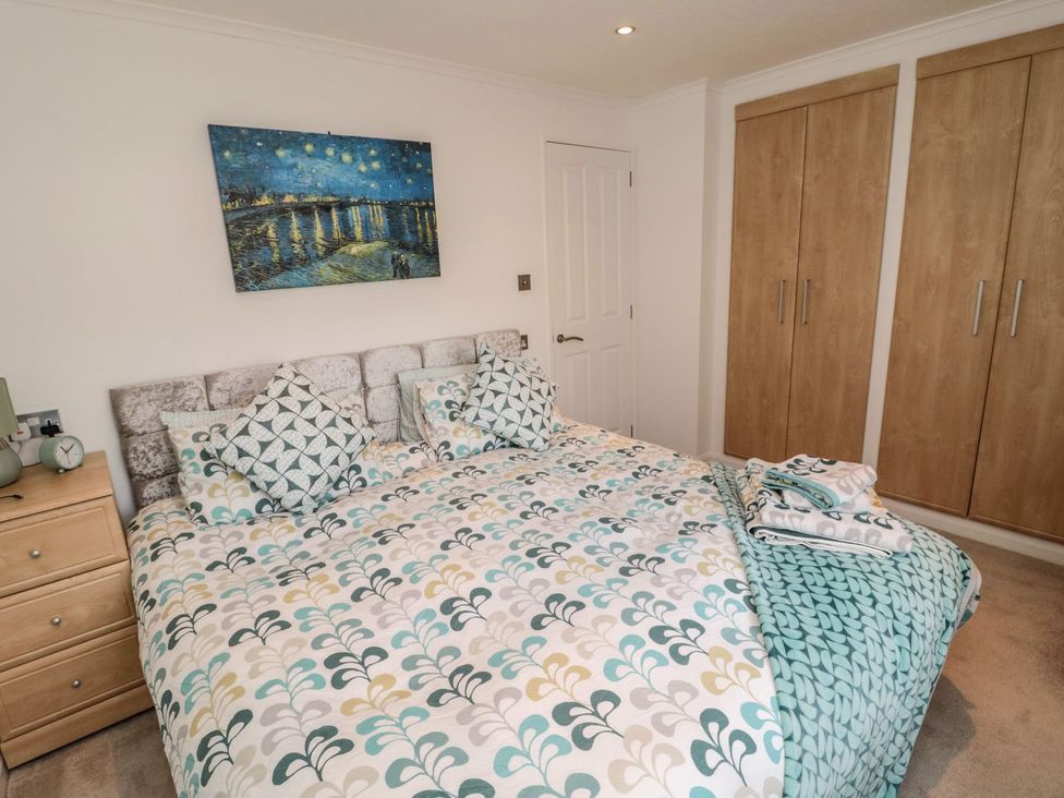A bedroom with a bed and wardrobe at Nevaeh Lodge in Longframlington