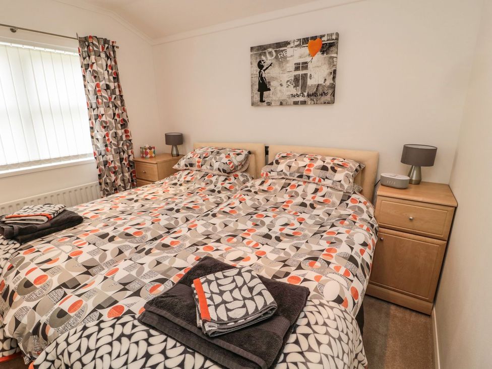 A bedroom with a double bed and bedside tables at Nevaeh Lodge Longframlington