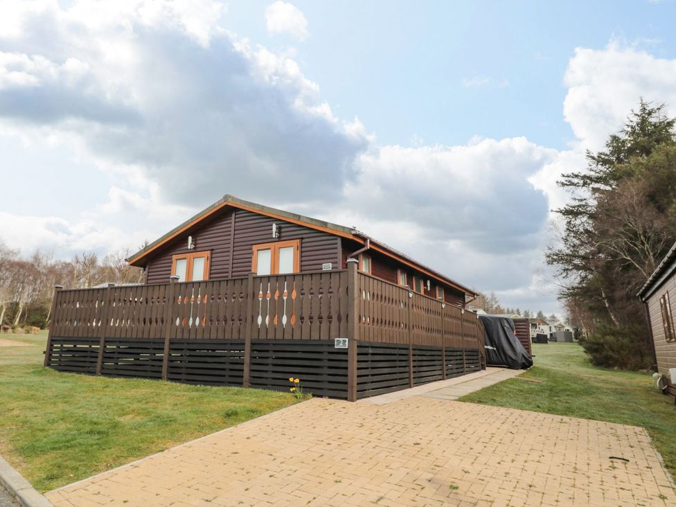 A lodge with decking and driveway at Nevaeh Lodge in Longframlington