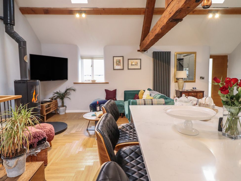 A living room with a fireplace and sofa at The Old Cartshed | Yr Hen Gwt Cart in Abergele