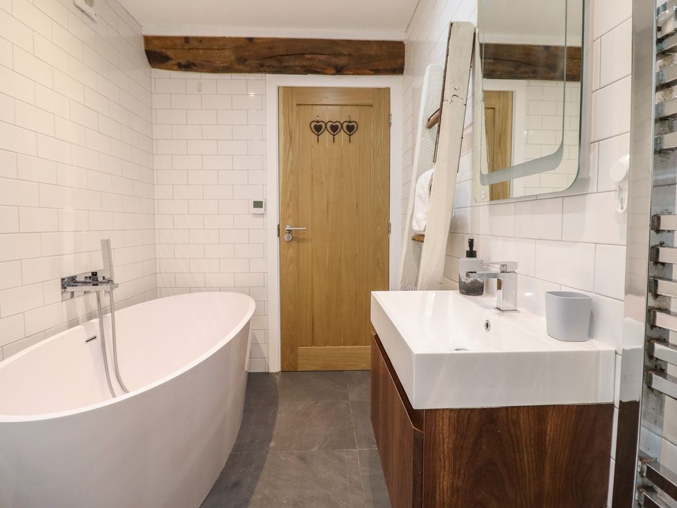 A bathroom with a bathtub and sink at The Old Cartshed | Yr Hen Gwt Cart, Abergele