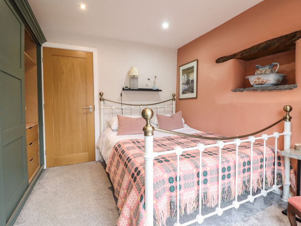 A bedroom with a bed and a bedside table at The Old Cartshed | Yr Hen Gwt Cart in Abergele
