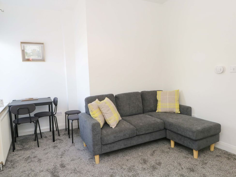 A living room with a sofa and a table at 4 Newton Terrace in Lancaster