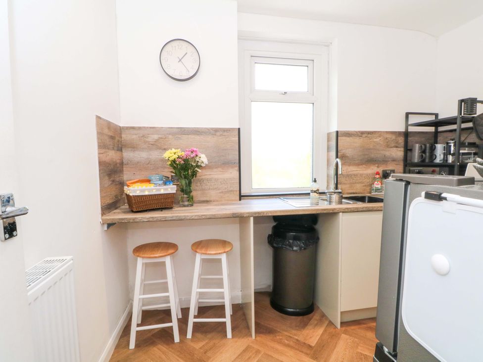 A kitchen with stools and a sink at 4 Newton Terrace in Lancaster