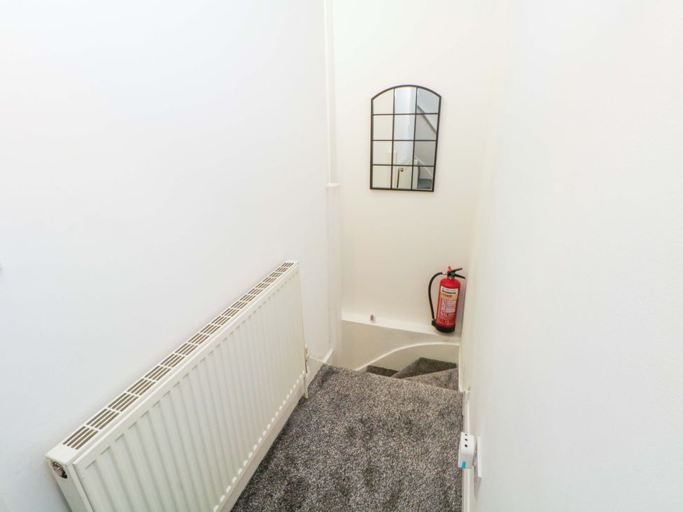 A staircase with a mirror and a fire extinguisher at 4 Newton Terrace in Lancaster
