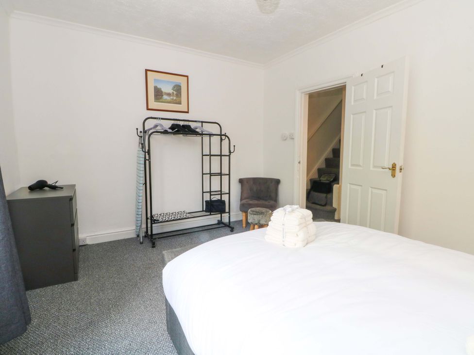 A bedroom with a bed, clothes rack, and dresser at 4 Newton Terrace in Lancaster