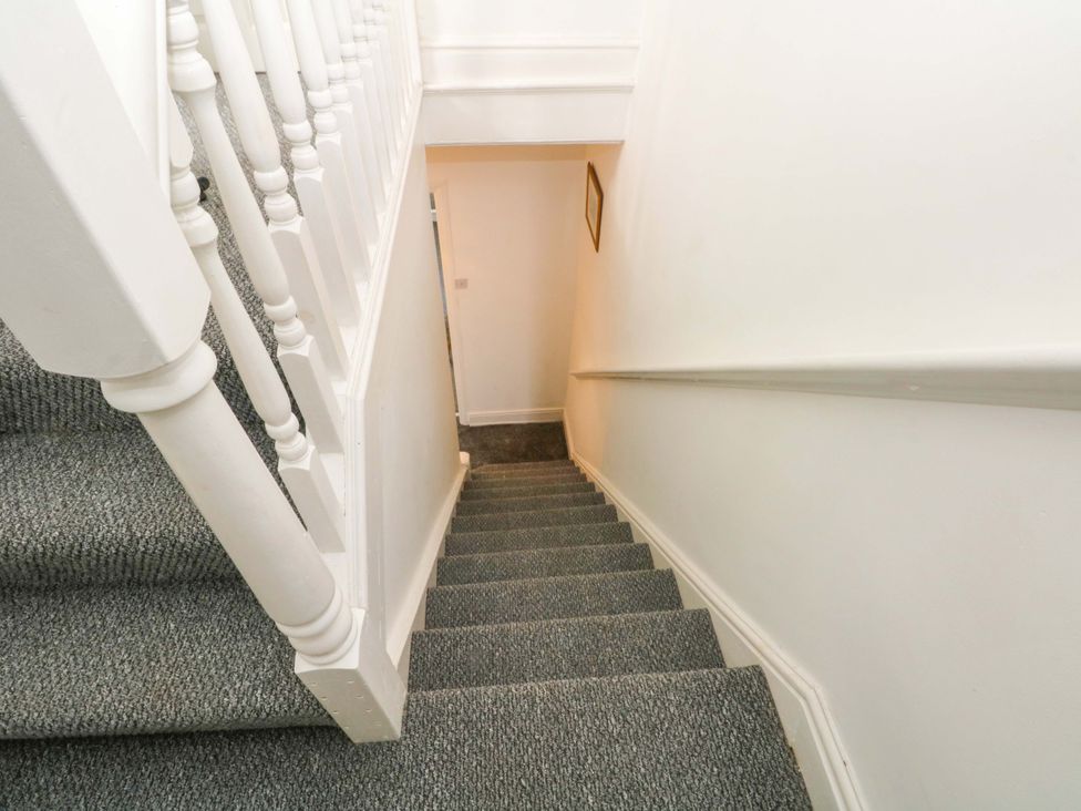 A staircase leading down with a handrail and carpet at 4 Newton Terrace in Lancaster