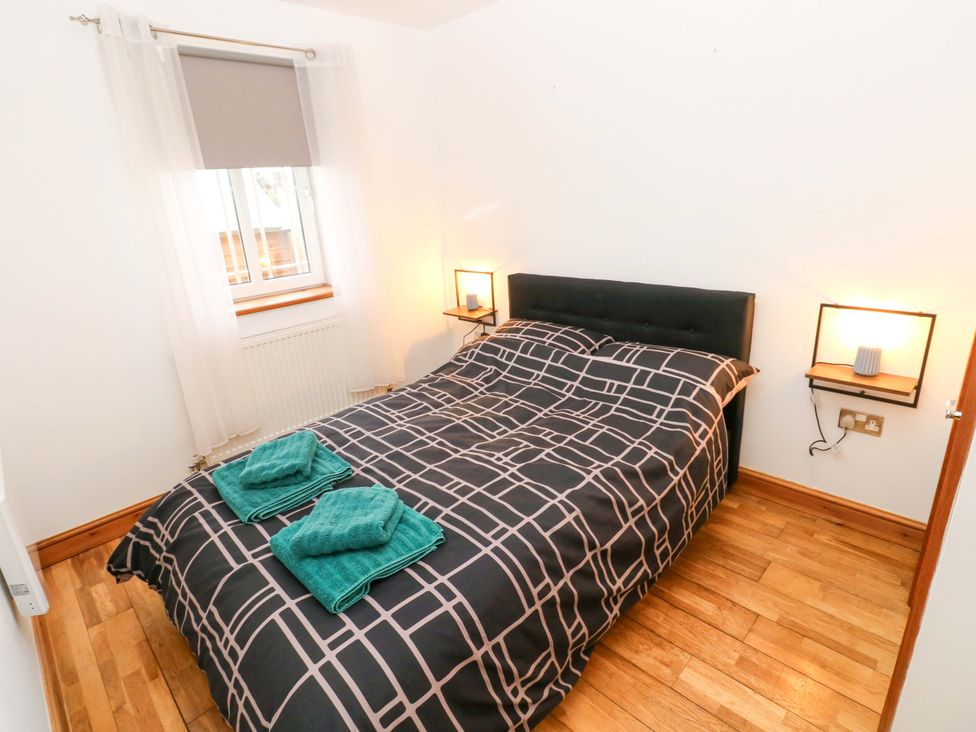 A bedroom with a double bed and towels on it at Red Kite Cottage in Haverfordwest