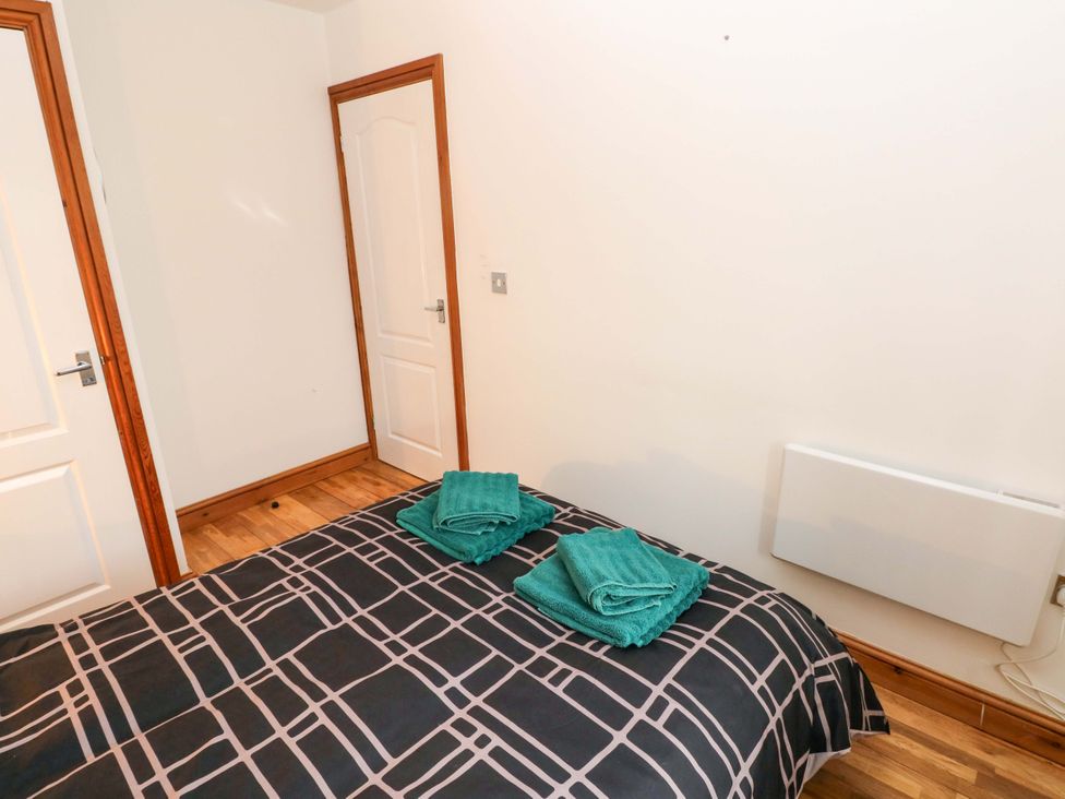 A bedroom with a bed and folded towels at Red Kite Cottage Haverfordwest