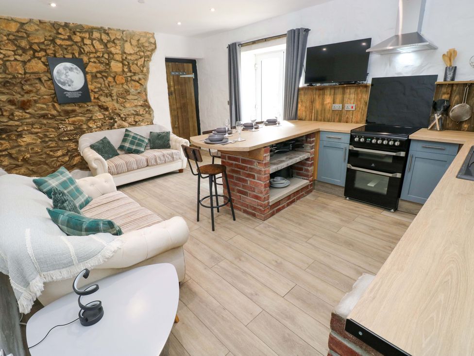 A kitchen with a sofa and kitchen setup at Woodpecker in Haverfordwest