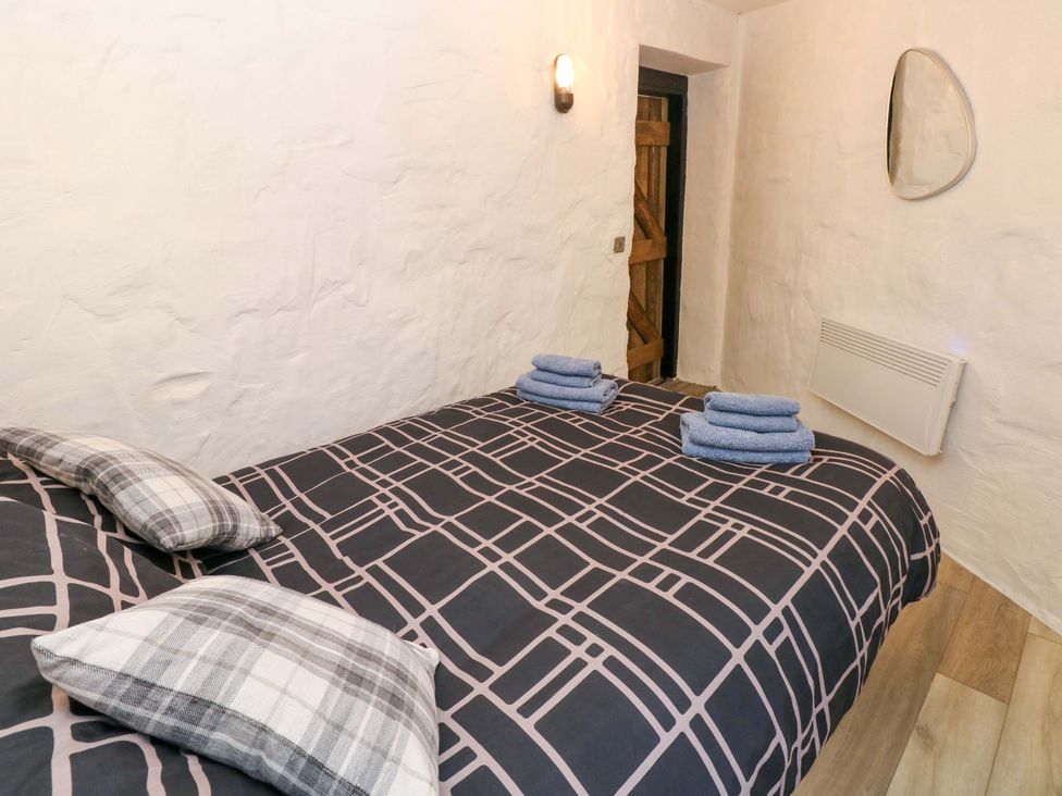 A bedroom with a bed and towels at Woodpecker in Haverfordwest