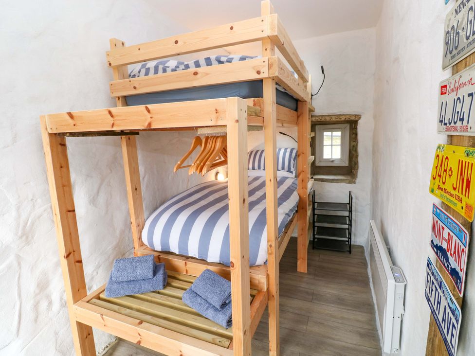 A bedroom with a bunk bed and towels at Woodpecker in Haverfordwest