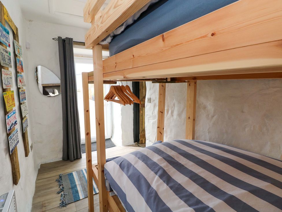 A bedroom with a bunk bed and a mirror at Woodpecker in Haverfordwest