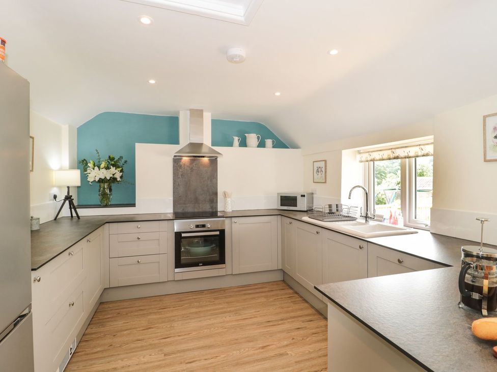 A kitchen with cabinets, oven, sink and microwave at Ammerham Farm Cottage Ammerham near Winsham