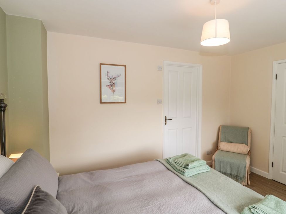 A bedroom with a bed and a chair at Ammerham Farm Cottage Ammerham near Winsham