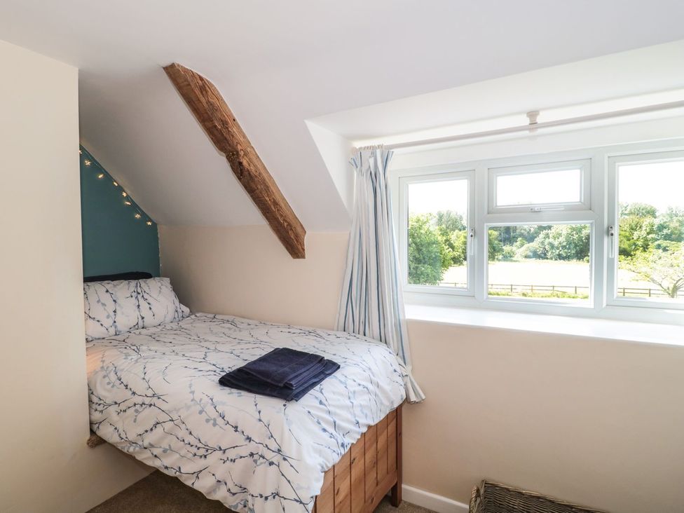 A bedroom with a bed and window overlooking the countryside at Ammerham Farm Cottage Ammerham near Winsham