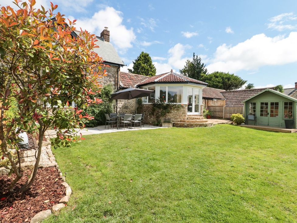 A garden with seating and a green shed at Ammerham Farm Cottage Ammerham near Winsham