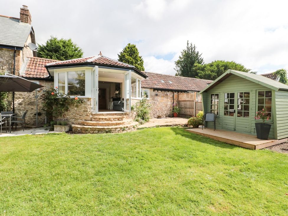 A garden with a patio area and a shed at Ammerham Farm Cottage Ammerham near Winsham