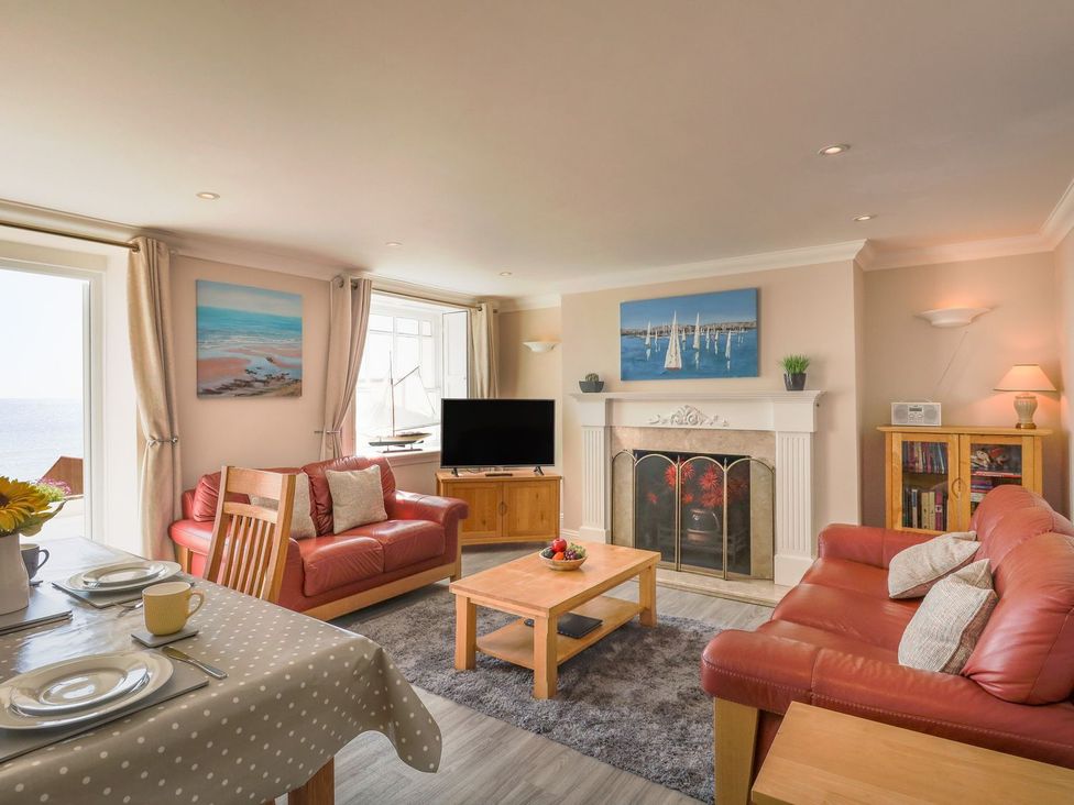 A living room with a sofa, coffee table, and fireplace at Ocean Wave in Greenhill