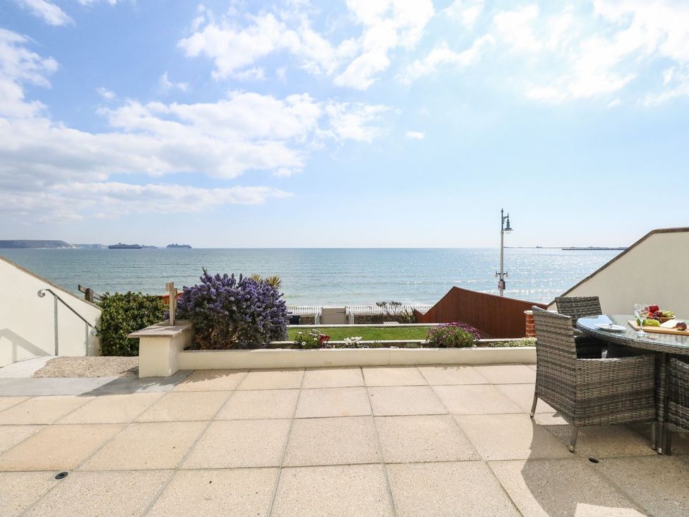 A patio area with a sea view at Ocean Wave in Greenhill
