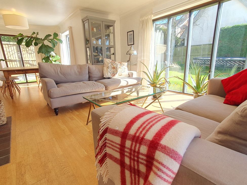 A living room with a sofa, coffee table and plants at Island Retreat in Colchester