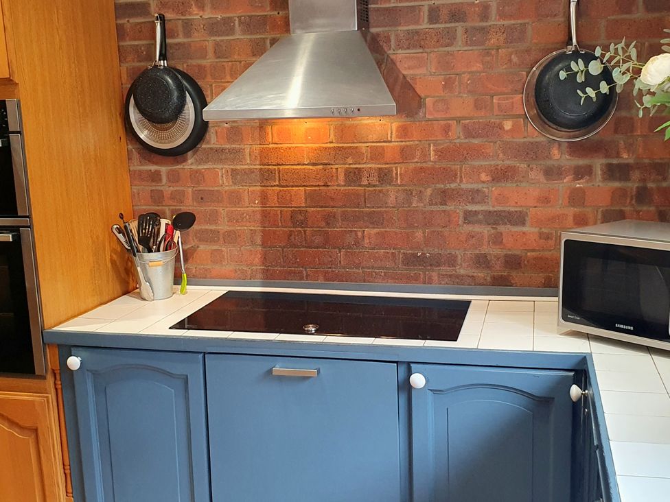 A kitchen with a stove and microwave at Island Retreat in Colchester