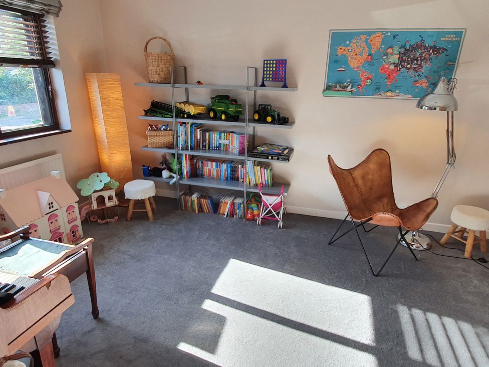 A playroom with a bookshelf and toys at Island Retreat in Colchester