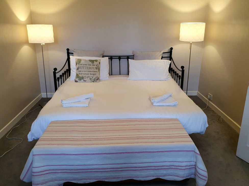 A bedroom with a bed and lamps at Island Retreat in Colchester