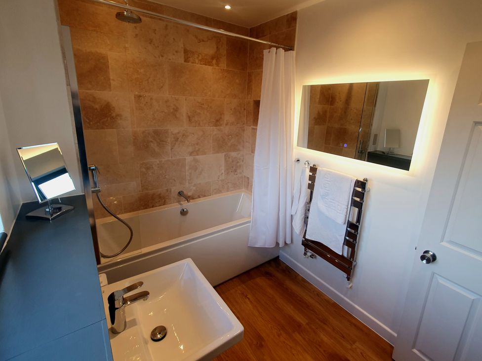 A bathroom with bathtub and towel rack at Island Retreat in Colchester