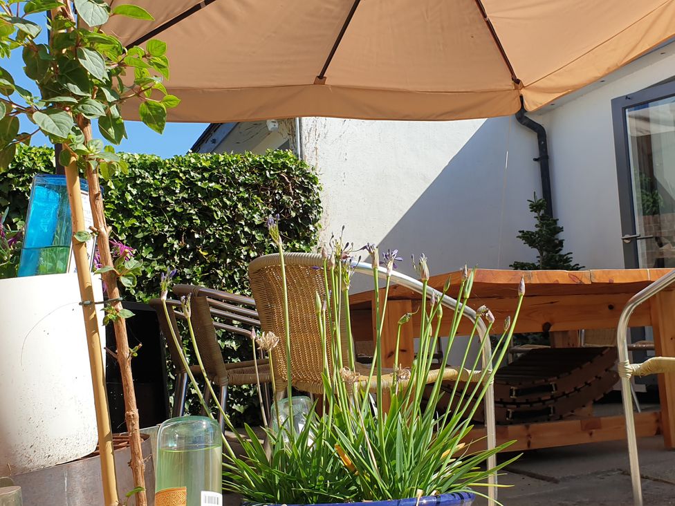 A garden with a table and chairs under an umbrella at Island Retreat in Colchester