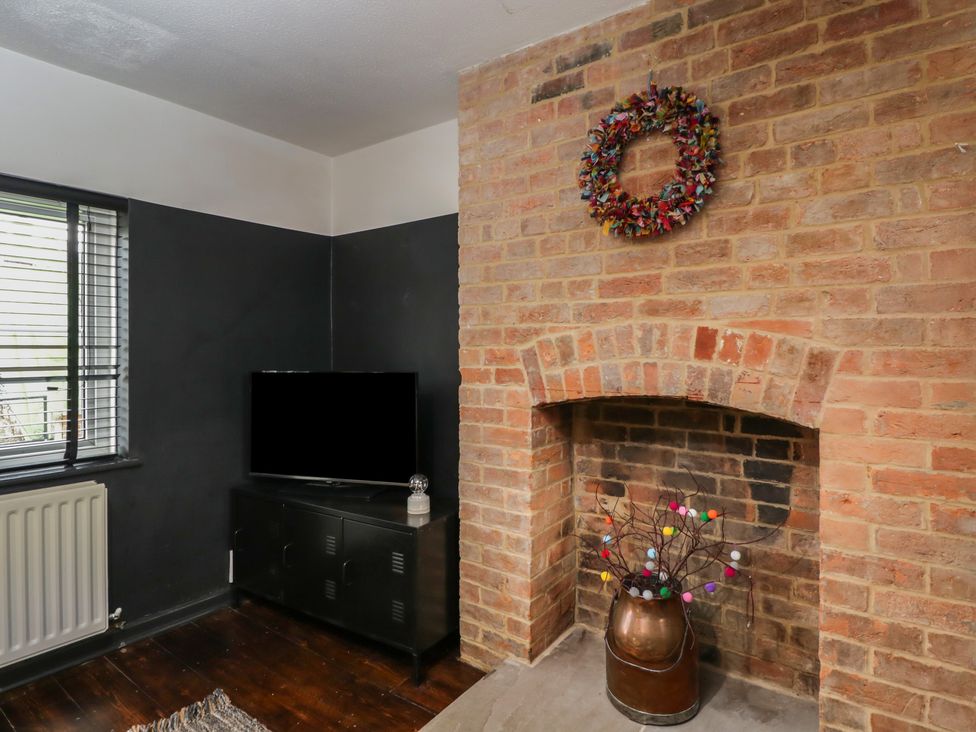 A living room with a television and fireplace at Copper Cottage in Devizes