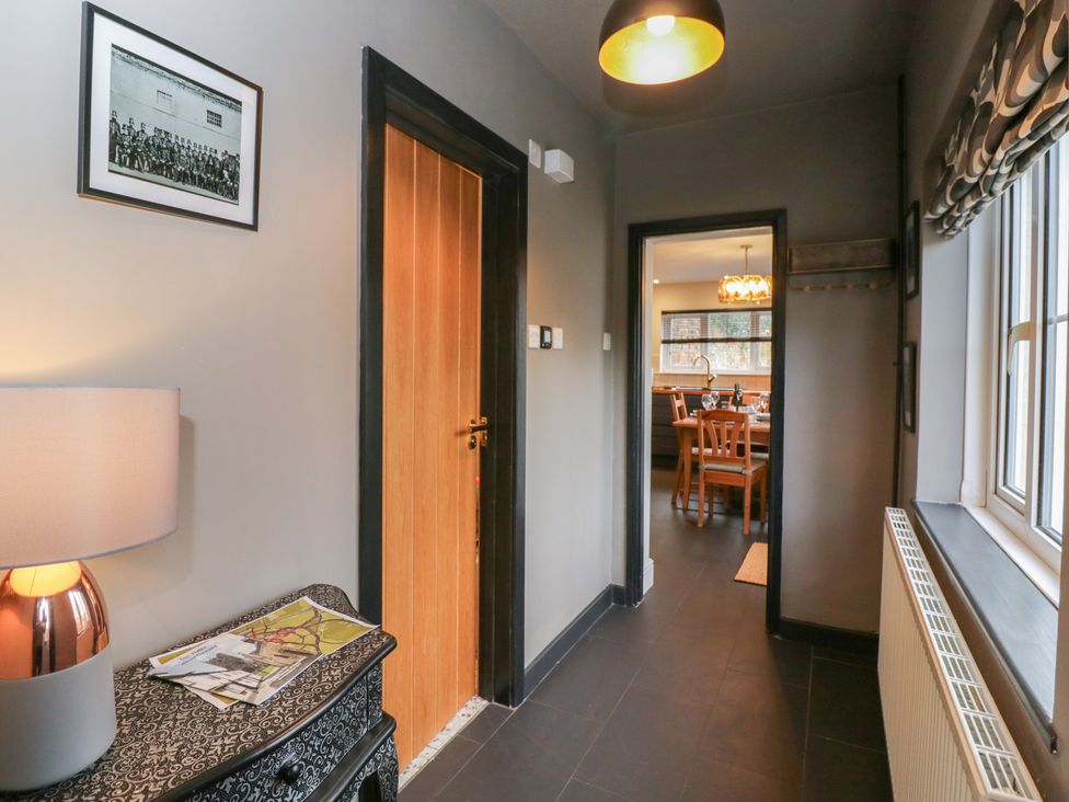 A hallway with a lamp and door viewed towards the dining area at Copper Cottage in Devizes