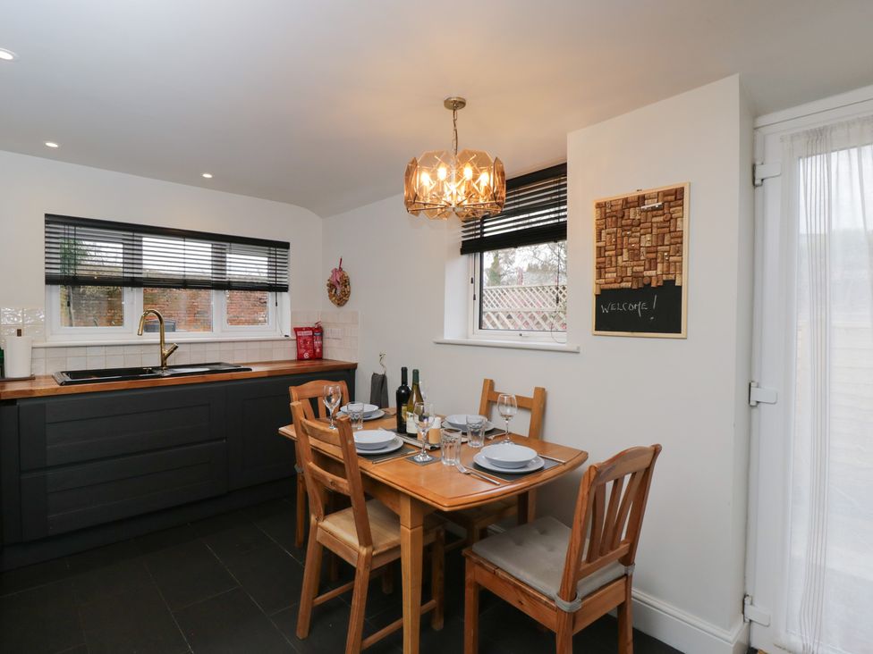 A kitchen with a dining table set for four at Copper Cottage in Devizes