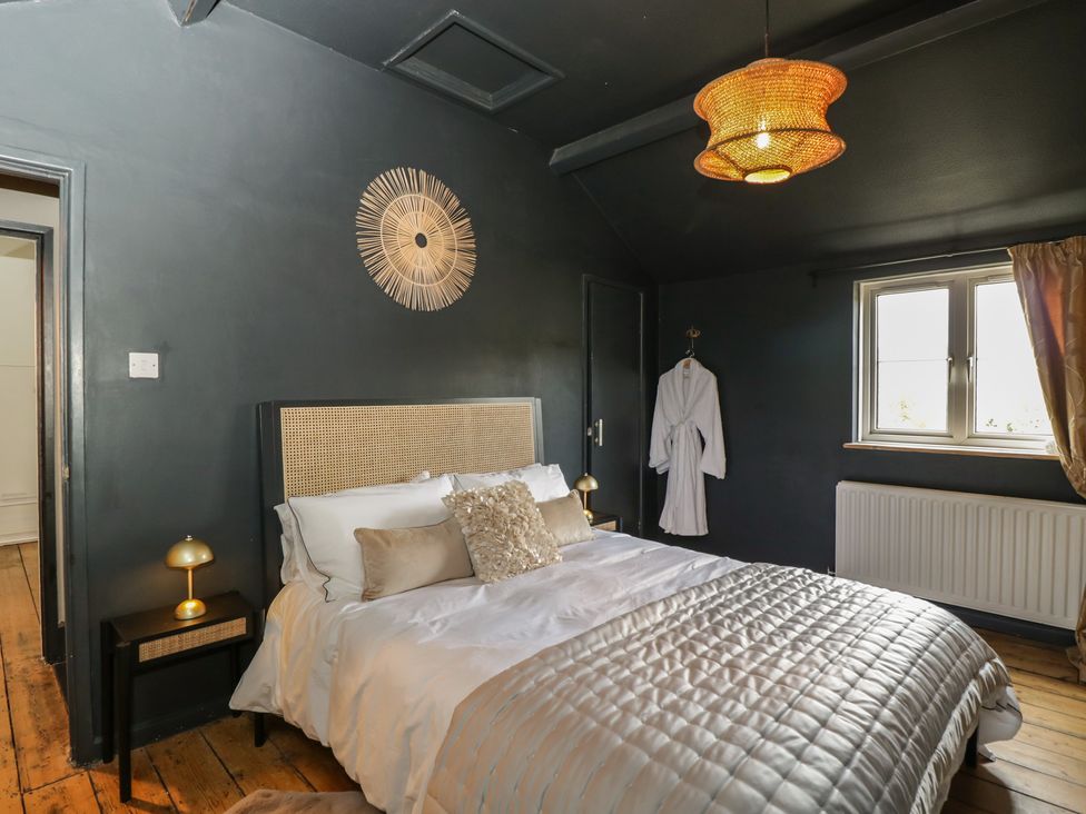 A bedroom with a bed and nightstand at Copper Cottage in Devizes