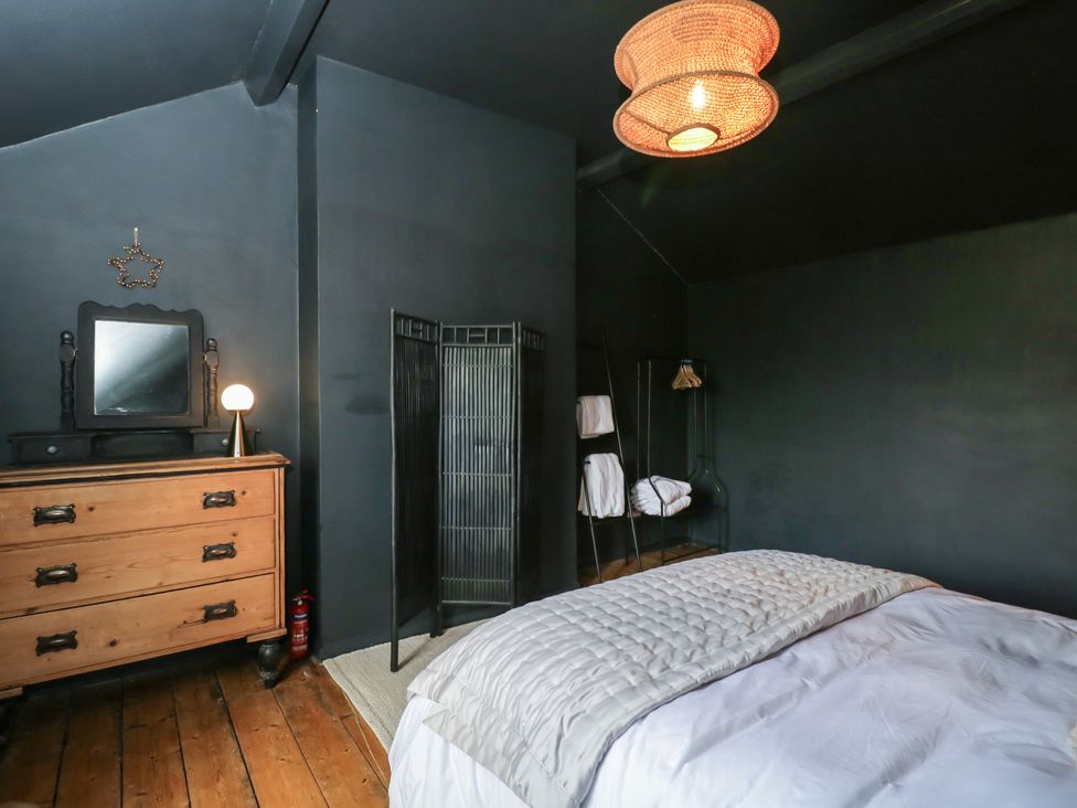A bedroom with a bed and dresser at Copper Cottage in Devizes