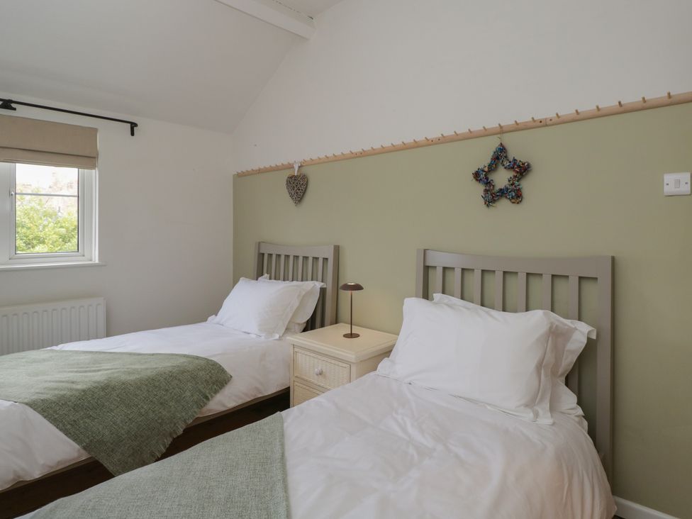 A bedroom with two single beds and a nightstand at Copper Cottage in Devizes