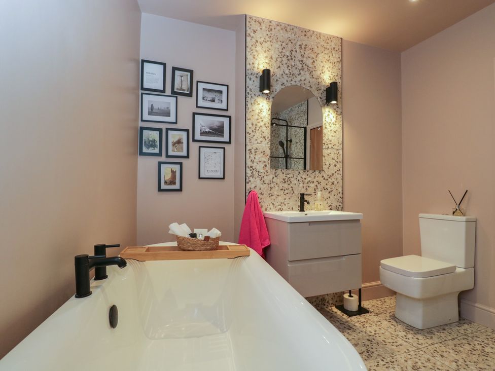 A bathroom with a bathtub and sink at Copper Cottage in Devizes
