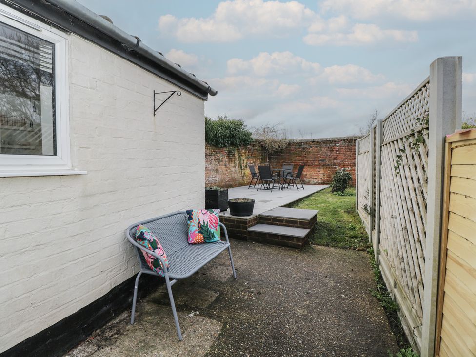 A garden with a bench, table and chairs at Copper Cottage in Devizes