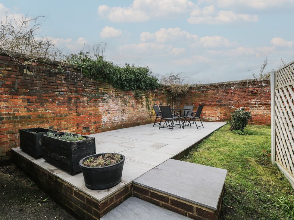 A garden with a patio, table and chairs at Copper Cottage in Devizes