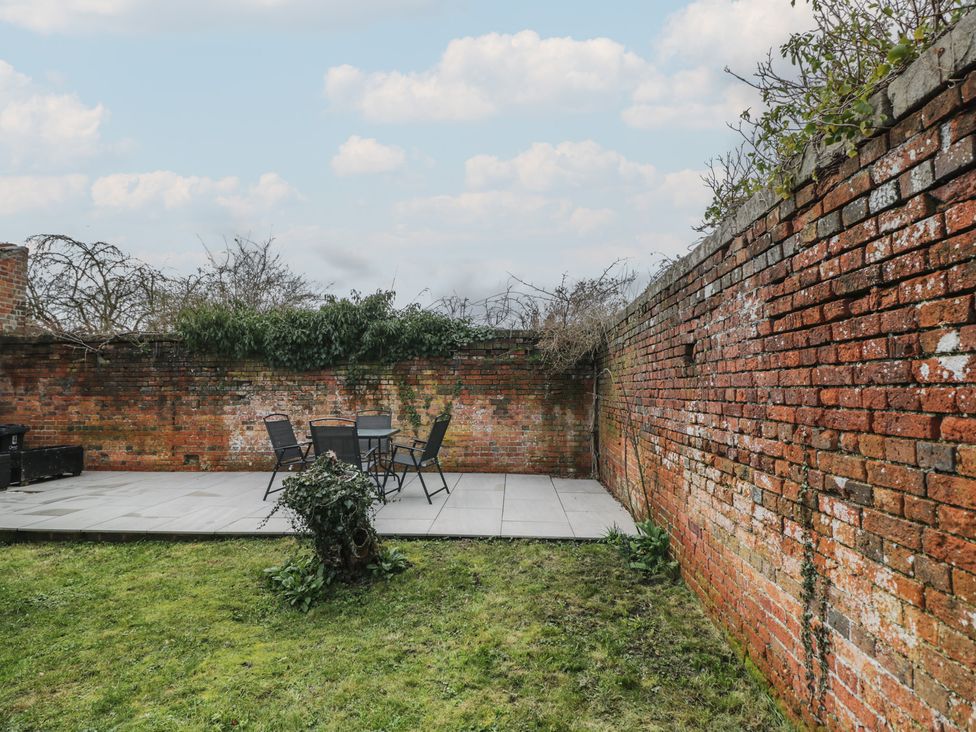 A garden with a paved area and seating at Copper Cottage in Devizes