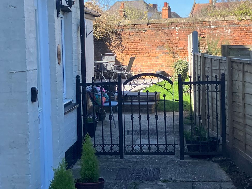 A pathway leading to a garden gate at Copper Cottage in Devizes
