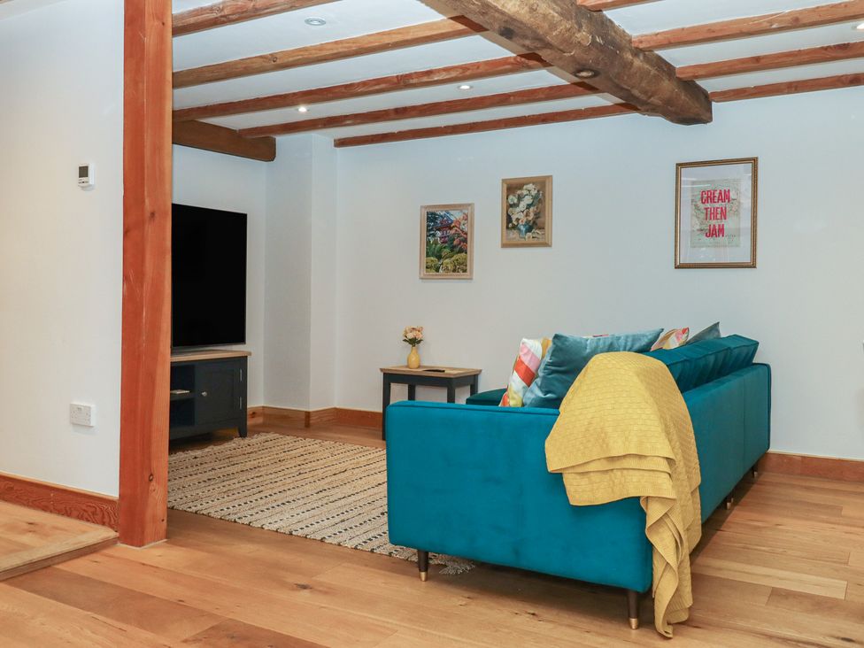 A living room with a sofa and TV at Pylemoor Cottage in Washfield near Tiverton